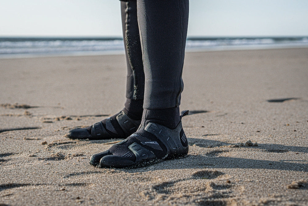 Peron on the beach wearing O'Neill Psycho Tech Split Toe neoprene boots.