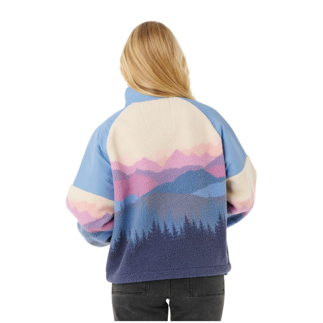 Person wearing a colorful mountain-patterned jacket on a white background