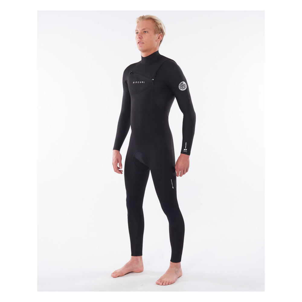 A male model wearing a black mens dawn patrol 5/3mm chest zip wetsuit with the brand name 'Rip Curl' on the chest. Side view.